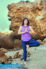 Woman doing yoga on a beach