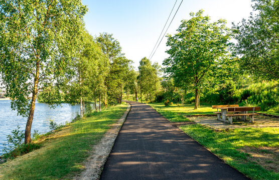 A picnic table with benches near scenic river going from Algard town, Norway, June 2018