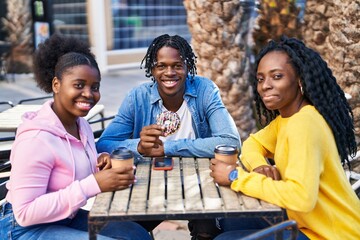 African american friends having breakfast sitting on table at coffee shop terrace