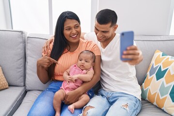 Hispanic family having video call sitting on sofa at home