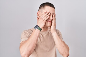 Young man standing over isolated background rubbing eyes for fatigue and headache, sleepy and tired expression. vision problem