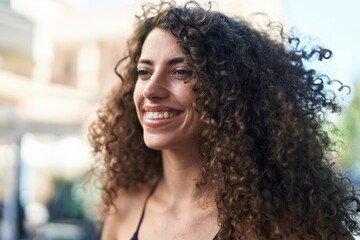 Fototapeta premium Young beautiful hispanic woman smiling confident looking to the side at street