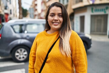 Fototapeta premium Young beautiful plus size woman smiling confident standing at street