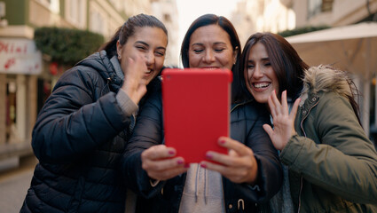 Mother and daugthers having video call hugging each other at street