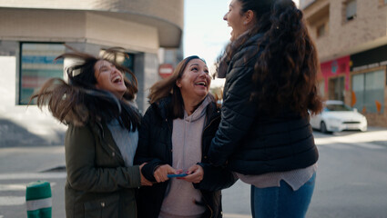 Fototapeta premium Mother and daugthers using smartphone standing together at street