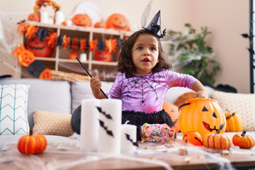 Fototapeta premium Adorable hispanic toddler having halloween party standing at home