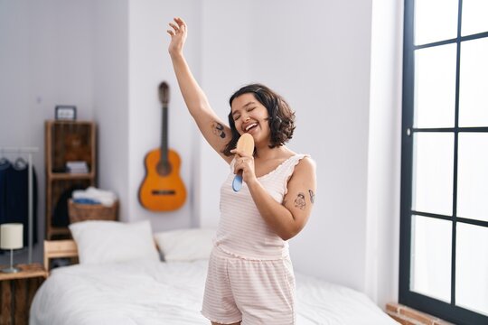 Young woman smiling confident singing song at bedroom
