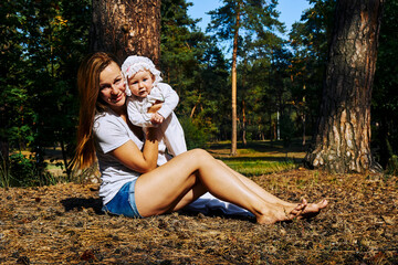  Young pretty mother with a cute breast newborn baby in a sunny forest