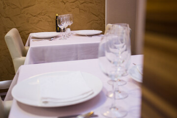 Elegant restaurant table with cutlery, crockery and glasses.