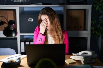 Obraz premium Young caucasian woman working at the office at night tired rubbing nose and eyes feeling fatigue and headache. stress and frustration concept.