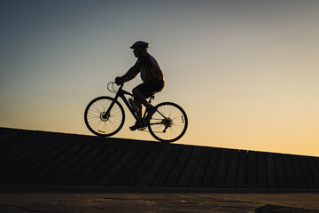 Obraz premium Cyclist Silhouette Against a Beautiful Summer Sunset 
