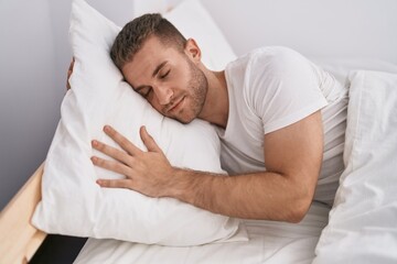 Fototapeta na wymiar Young caucasian man lying on bed sleeping at bedroom