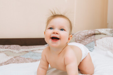 a funny baby crawling in the nursery at home. the baby is 6 months old learning to crawl