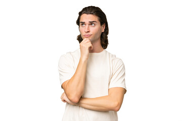 Young caucasian man isolated on green chroma background having doubts and thinking