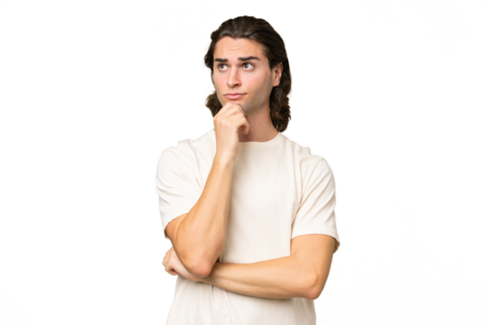 Young caucasian man isolated on green chroma background having doubts and thinking