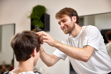 caucasian man getting haircut by professional male hairstylist