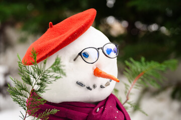 The portrait of a snowman in the garden. Close up view with a snow man build in backyard. Winter...