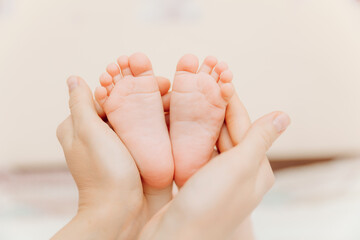 Baby feet in mother's hands. Mom and her child. happy family concept. baby feet