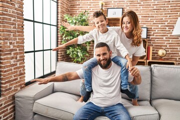 Family smiling confident playing sitting on sofa at home