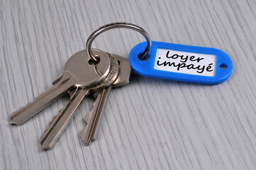 Trousseau de clés avec un porte-clés sur lequel est écrit loyer impayé
