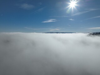 Aerial View. Flying over the high mountains in beautiful clouds. Aerial Drone camera shot. Air pollution clouds over Sarajevo in Bosnia and Herzegovina. 