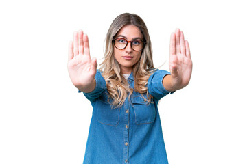 Young Uruguayan woman over isolated background making stop gesture and disappointed