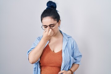 Young modern girl with blue hair standing over white background tired rubbing nose and eyes feeling fatigue and headache. stress and frustration concept.