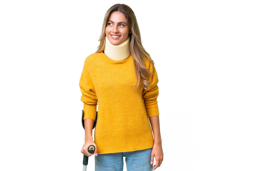 Young Uruguayan woman wearing neck brace and crutches over isolated background with happy expression