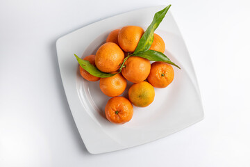 tangerines on a white plate on a white background
