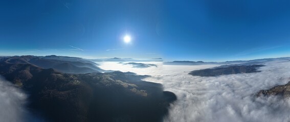 Aerial View. Flying over the high mountains in beautiful clouds. Aerial Drone camera shot. Air pollution clouds over Sarajevo in Bosnia and Herzegovina. 