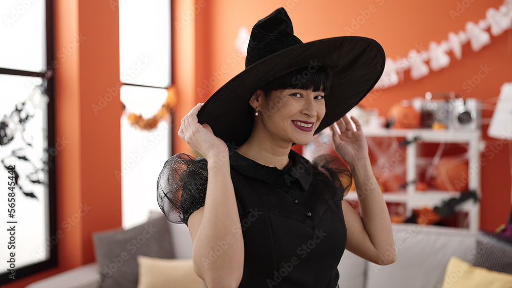 Sticker Young chinese woman wearing witch costume having halloween party at home