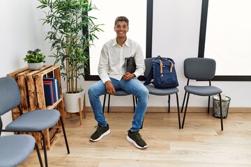 Young hispanic man waiting at waiting room