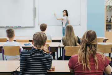 Young teacher is standing in front of the blackboard during sex education lesson - 565847083