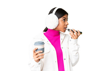 Young African American woman wearing winter muffs over isolated chroma key background holding...