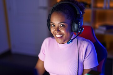 African american woman streamer smiling confident sitting on table at gaming room