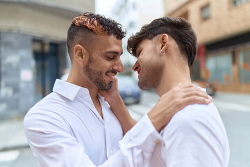 Two hispanic men couple smiling confident hugging each other at street