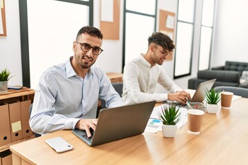 Two hispanic men business workers smiling confident working at office