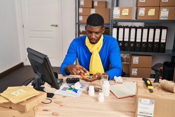 Young african american man ecommerce business worker taking pills treatment at office