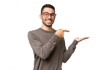 Young handsome caucasian man over isolated background holding copyspace imaginary on the palm to insert an ad