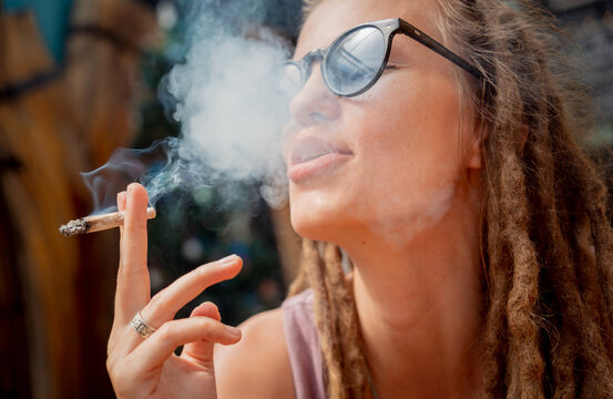 Hippie style woman smoking cigarettes with medical marijuana