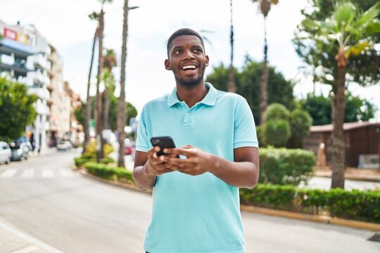 Young african american man smiling confident using smartphone at park