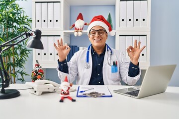 Hispanic young doctor man at the clinic on christmas relax and smiling with eyes closed doing meditation gesture with fingers. yoga concept.
