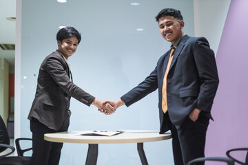Asian cheerful young businessman hand shake for dealing project at the office