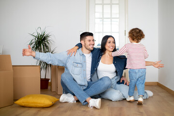 Happy family with little son having fun at new home after moving