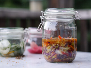Fermentiertes roh veganes eingemachtes Gemüse, Sauerkraut und Kimchi im Einmachglas 