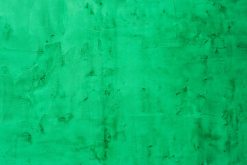 Green paint painted on rough wall background .