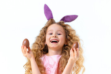 Obraz na płótnie Canvas Happy holiday easter kids. Smiling cute little beautiful girl with rabbit hare bunny ears playing with chocolate eggs
