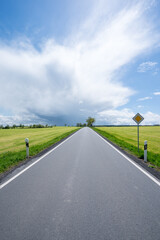 Straße im Sommer mit dramatischer Wolke