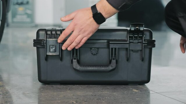 The Mechanic Opens A Large Black Tool Box. Close-up Of A Hand Opening A Box.