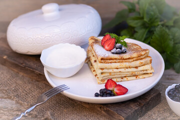 Pancakes Thin homemade pancakes with berries, traditional Russian cuisine. Homemade pancakes with berries